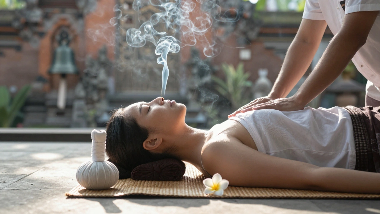 A person sitting peacefully after a massage, incense smoke rising, herbal compress beside them, dawn light illuminating the floor.